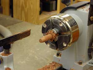 Turning a bubinga dowel for portholes.